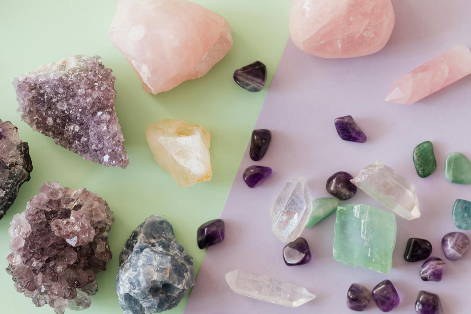 A variety of crystals and gemstones including amethyst and rose quartz on a pastel background.